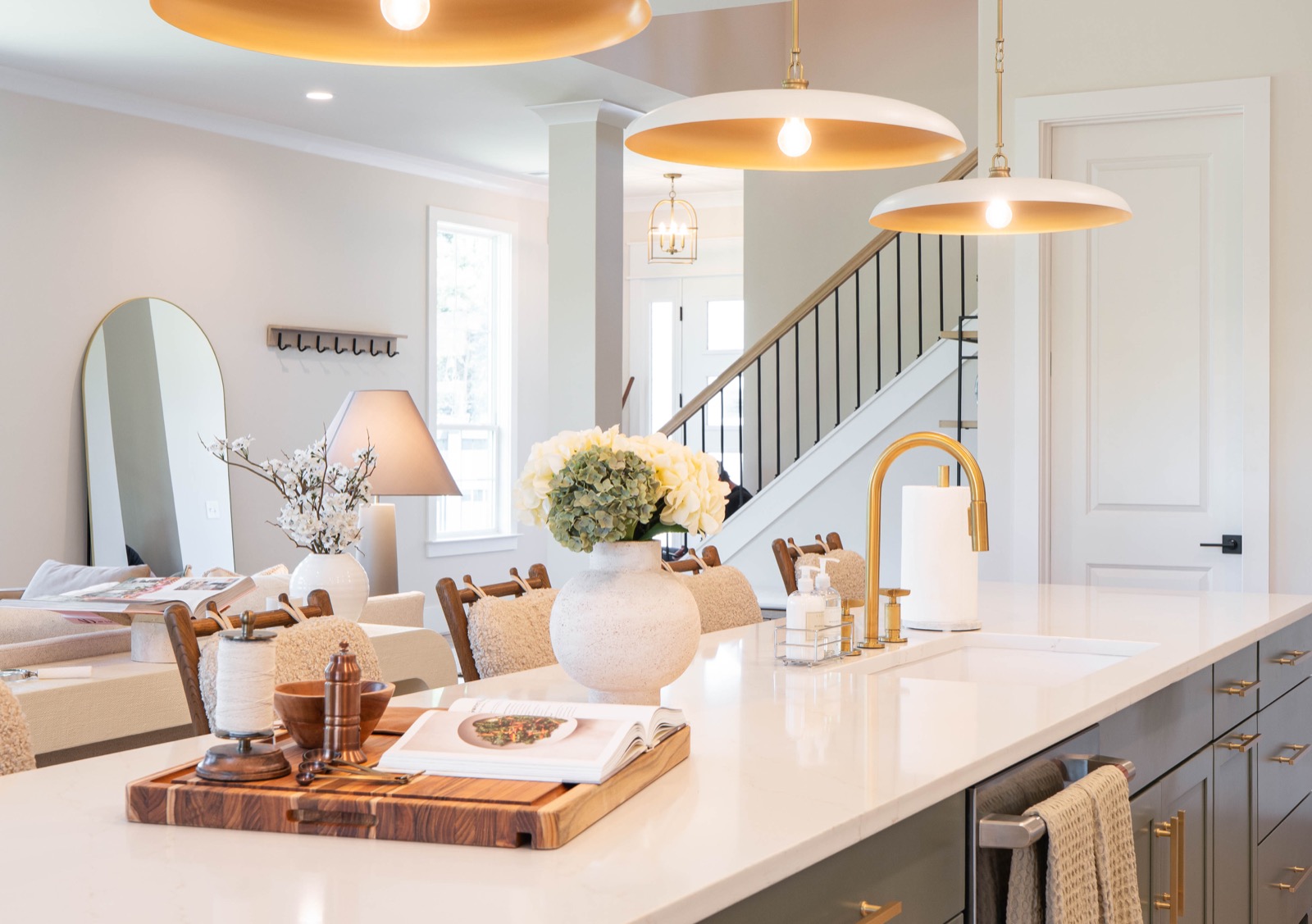 Staged kitchen island with brass pendants and fresh hydrangeas