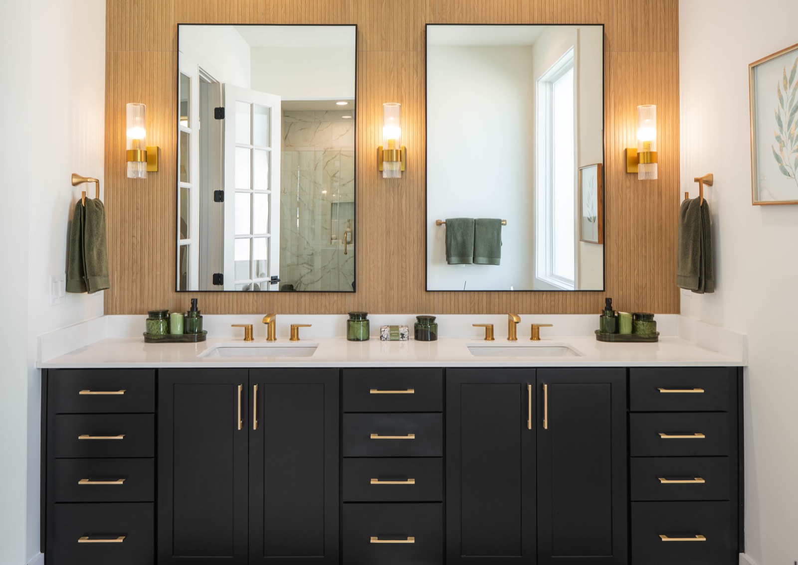 Bathroom double vanity in black cabinetry with warm wood accents