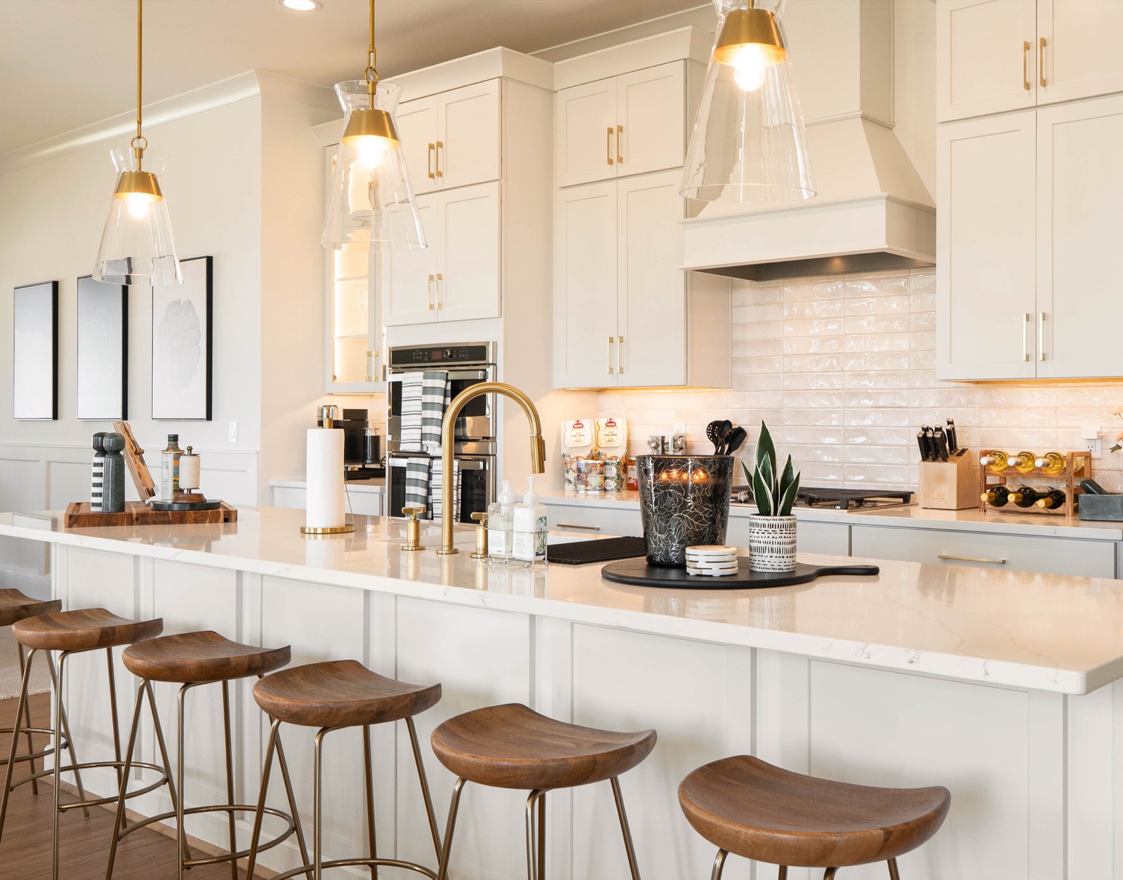 White kitchen island lined with walnut counter stools