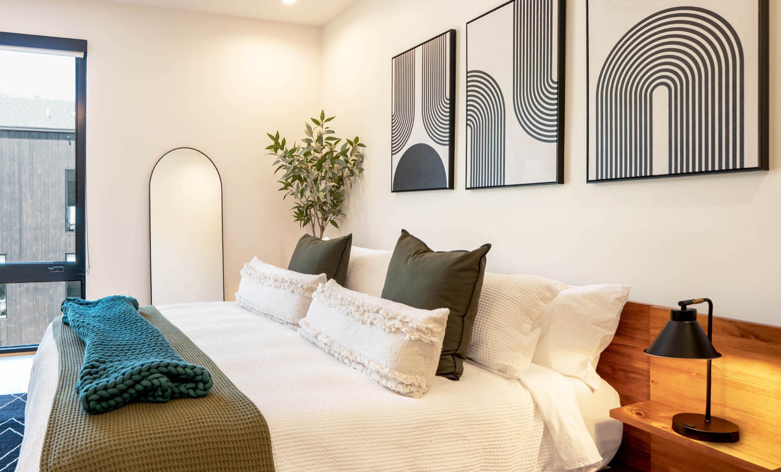 Modern bedroom styled with graphic art and olive green accents