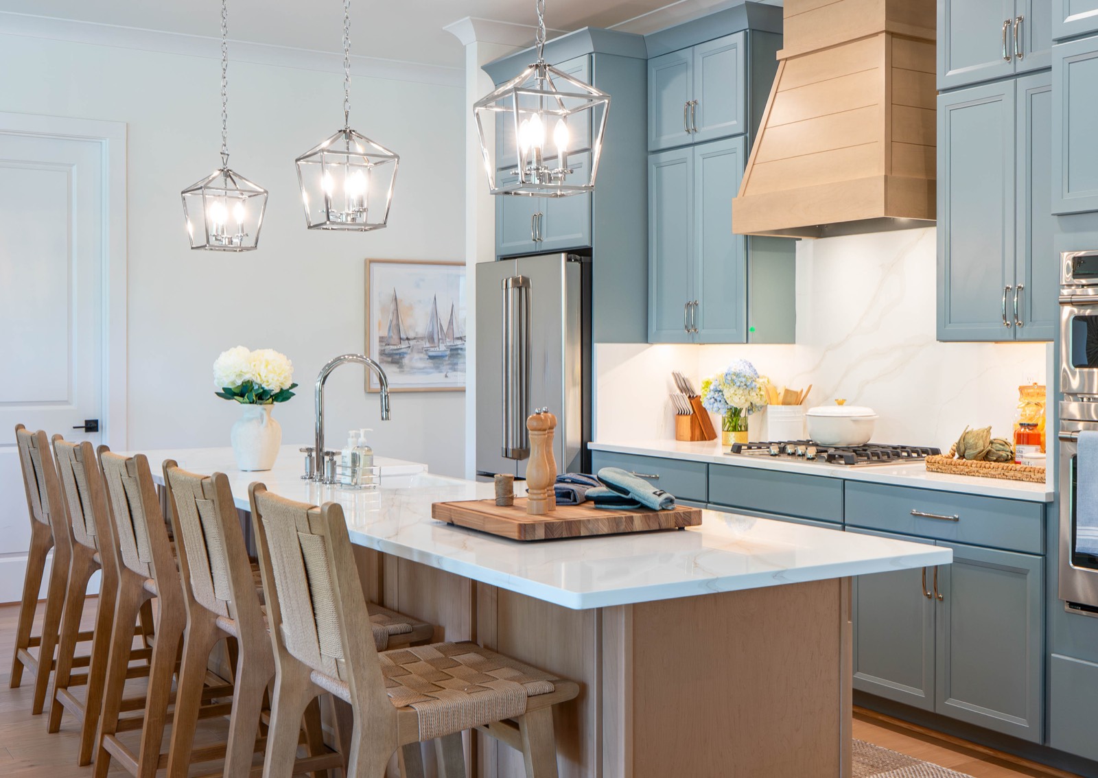 Coastal kitchen with blue cabinetry and woven counter stools